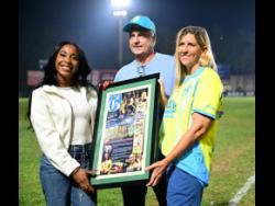 Shelly-Ann Fraser-Pryce (left) recieves a citation from the Waterhouse Football Club, presnted by Bruce Bicknell (chairman, Waterhouse FC) and Nicola Bicknell (director, Waterhouse FC) in honour of her achievements in track and field. The presentation took place at half-time during the Molynes FC vs Waterhouse FC Jamaica Premier League fixture.