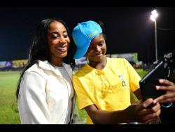Amoya McBean (right), sporting her Waterhouse FC cap takes a photo with Shelly-Ann Fraser-Pryce at the Waterhouse Mini Stadium in Drewsland on Sunday. Fraser-Pryce was presented with a citation as part of the recognition by the football club.