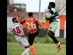 Chapelton Maroons’ Osani Ricketts reacts as his goalkeeper, Daniel Smith catches the ball while under pressure from Tivoli Gardens’ Akeil Leachman during the Jamaica Premier League football match at Edward Seaga Sports Complex yesterday. Tivoli won 2-0.