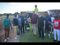 LEGACY ISLES (centre), with Raddesh Roman in the saddle, parades with connections after winning the Chris Harmond Memorial Sprint over 5 1/2 furlongs at Caymanas Park on Saturday.
