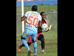 Racing United’s goalkeeper Aaron Enill catches the ball ahead of Waterhouse FC striker Atapharoy Bygrave during their Jamaica Premier League football match at Ferdi Neita Park on Sunday. The game ended 0-0.