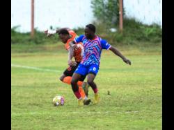 Akeil Leachman of Tivoli Gardens FC (left) battles for the ball with Akeem Mullings of Portmore United FC during the Jamaica Premier League football match at Edward Seaga Sports Complex in Kingston. The game ended 2-2.
