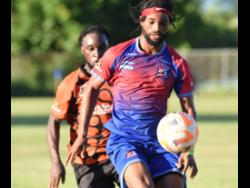 File photo shows Dunbeholden’s Chevoy Watkin (front) as he controls the ball under the watchful eyes of Tivoli Gardens FC’s Anthony Nelson during their Jamaica Premier League football match. Nelson was on target for Dunbeholden during their 4-0 rout of Treasure Beach FC..