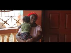 Grief and comfort intertwine as Janet Henry hugs her 18-month-old grandson.