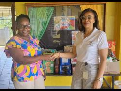 Kareen Dennis (right), secretary of the JN Circle Linstead Chapter, presents breakfast supplies to Annette Steele, principal of Victoria Primary School.