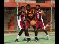 Holmwood Technical High’s Romeo Smith (centre) is swarmed by Herbert Morrison Technical High’s Shaheem Salmon (left) and Christopher Morrison during their ISSA under-19 basketball quarterfinal match at Herbert Morrison on Friday.