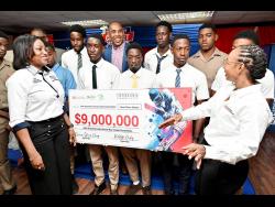 Terry-Ann Graver (left), COO of First Global Bank; and Tammara Glaves-Hucey (right), managing director of GK General Insurance, present the value of their company’s ISSA sponsorship to schoolboy cricketers and ISSA president Keith Wellington (centre, back row) during the launch of the ISSA Grace Shield and ISSA Grace Headley Cup. Both competitions are powered by First Global Bank and GK General Insurance. The launch was held at Grace Foods Multi-Function Room on Harbour Street, Kingston, on Thursday.