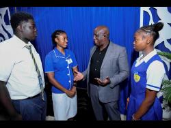 Ricky Martin (second right), CEO of Corporate Area Championships, in dialogue with Ricardo Smith, discus and shot put athlete of Penwood High School (left), Shanakay Morris, discus and shot put athlete of Penwood High School (right), and Dacia McDonald, javelin and shot put athlete of Immaculate High School, at the media launch for the Corporate Area Champs on February 10 at the National Housing Trust Sports Club. 