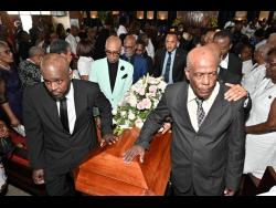 Terrence Kelly (right), husband, and Daviot Kelly (left), son of the late Joan Vivene Kelly, join pallbearers in carrying her casket during the service of thanksgiving for her life at Meadowbrook United Church on Flemington Drive in Kingston on Friday, February 20, 2026. Kelly was a former vice-principal of Holy Childhood High School.