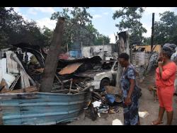 Passers-by look at what is left of the homes.