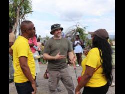 Comedian Harry ‘White yardie’ Gregory (centre) was in a jovial mood as he spoke to a member of the JN Money team while Horace Hines (left), general manager, JN Money, listens during a recent medical mission in Parottee Bay, Black River, St Elizabeth, recently. White Yardie, in collaboration with JN Money and the JN Foundation, organised the medical mission, which was supported by St John’s Ambulance. 