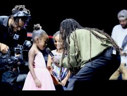 Jesse Royal is joined on stage by daughter Korus (left) and her friend Nyah El during his performance on day two of Lost In Time Festival at Hope Gardens on Sunday.