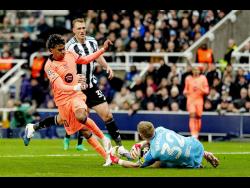 Newcastle’s goalkeeper Aaron Ramsdale saves at the feet of Barcelona’s Lamine Yamal during the Champions League round-of-16 first-leg soccer match in Newcastle, England, on Tuesday, March 10.
