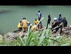 The body of 17-year-old Oshene Darby is taken from the Rio Cobre in the Bog Walk Gorge on Tuesday, after the vehicle he was reportedly driving plunged into the river on Monday night.