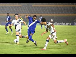 Mount Pleasant FA’s Demario Phillips (second right) takes a shot at goal as he comes under pressure from LA Galaxy’s Isaiah Parente (left) and Mauricio Cuevas during the Concacaf Champions Cup football match at the National Stadium on Thursday. LA Galaxy won 3-0.