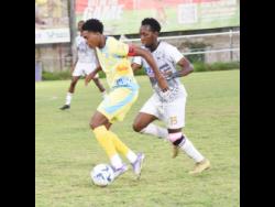 Ky-Mani Campbell of Waterhouse FC is pressured for the ball by Dwayne Allen (right) from Cavalier SC during the Jamaica Premier League football match at Drewsland Mini Stadium on Sunday.