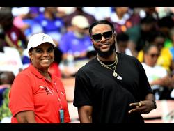 Meet official Olive McNaughton with Jamaica’s 100m sprinter Kishane Thompson on the final day action of the ISSA GraceKennedy Boys’ and Girls’ Athletics Championships at the National Stadium on Saturday.