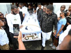 Pall-bearers carry the casket containing the body of Kerrio Pinnock from the Regent Street Seventh-day Adventist Church in Kingston yesterday.