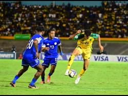 Jamaica’s Ian Fray (right) keeps the ball away from Sontje Hansen (centre) and Leandro Bacuna of Curacao during their Concacaf World Cup qualifying football match at the National Stadium in Kingston, on Tuesday, November 18, 2025.
