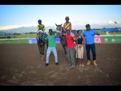 BARNABY (right), with champion Jockey Raddesh Roman in the saddle and stablemate NERO STAR, with Jahvaniel Patterson aboard, parade with connections after BARNABY won the Lloyd Linbergh “Lindy” Delapenha Memorial Trophy, ahead of NERO STAR over a mile at Caymanas Park on Sunday, February 8.