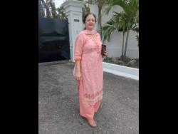 Tanuya Joshi, a visitor from India, captures the vibrant colours and energy of Carnival in Jamaica along East Kings House Road in St Andrew on April 12, 2026. 

