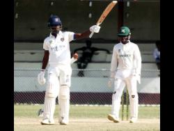 Barbados Pride’s Kevin Wickkham raises his bat after scoring 150 against Jamaica Scorpions on the opening day of their West Indies Championship cricket match against Jamaica at Chedwin Park in St Catherine on Sunday.
