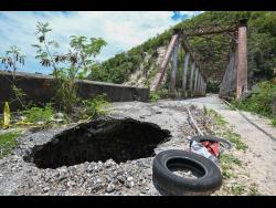 A gaping hole tears through the approach to the bridge in Easington, St Thomas.
