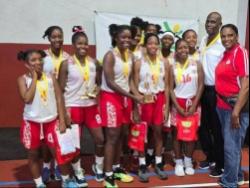 ISSA urban area schoolgirls basketball MVP Danae Brown (fourth from left) celebrates winning the title with teammates, Queen’s past student Olive McNaughton (right) and coach Donald Bimmer (second right), after they defeated St Andrew High 49-33 in the ISSA urban area final at UWI Bowl on Monday.