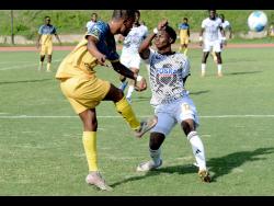 Mikyle Williams (left) of Racing United kicks the ball against Kimarly Scott of Cavalier SC during the Jamaica Premier League football match at Stadium East on Sunday.