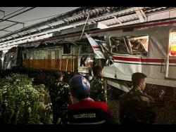 Indonesian soldiers examine the damage after a train crash at a station, in Bekasi, Indonesia, on Tuesday. 