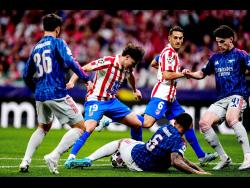 Atletico Madrid’s Julian Alvarez (centre) is blocked during the Champions League semifinal first leg soccer match against Arsenal in Madrid, Spain, on Wednesday. The match ended 1-1.