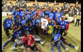 Jamaica College players celebrate with the ISSA/Digicel Manning Cup schoolboy football trophy after defeating St Andrew Technical High School (STATHS) 8-7 on penalties in the final on Friday night at Sabina Park. The scores were tied 1-1 at the end of regulation time.