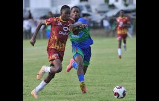 Addon Daye (left) of Wolmer’s Boys battles for the ball with Jahmon Thomas of  Vauxhall High during their Manning Cup match at The Mico University College yesterday. Wolmer’s won 4-2.