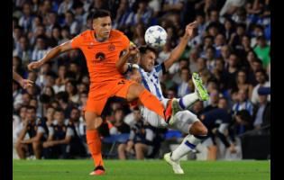 Inter Milan’s Lautaro Martinez (left) challenges Real Sociedad’s Martin Zubimendi for the ball during their Champions League football match at the Real Arena stadium in San Sebastian, Spain, yesterday. The game drew 1-1.