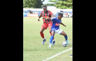 Mount Pleasant Football Academy’s Romeo Guthrie (right) tries to get by Montego Bay United’s Gregson President during their Wray and Nephew-sponsored Jamaica Premier League match at the Drax Hall yesterday. The game drew 1-1.