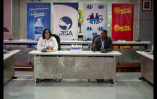 President of the Jamaica Independent Schools Association (JISA) Tamar McKenzie (left), listens to Mayor of Montego Bay Richard Vernon, as he endorses the return of JISA Western Track and Field Meet during the launch at the Chamber of the St James Municipal Corporation on Friday.