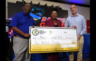 Olivia Grange (centre), minister of culture, gender, entertainment and sports and Allan Beckford (right), chairman, Sports Development Foundation, present a sponsorship cheque to Glen Mills, founder of the Racers Grand Prix, for the 2024 staging to be held at the National Stadium on June 1, 2024.