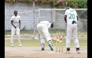 St. George’s College’s Demario Thorpe (centre) is bowled by Excelsior High’s Tamarie Redwood (left) for nought in the ISSA/GK Insurance Urban Area Twenty20 schoolboys cricket semi-final at St George’s College yesterday. Wicketkeeper David Dewar watched the action as Excelsior won by 10 wickets.