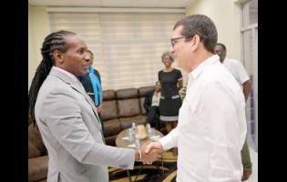 Minister of State in the Ministry of Foreign Affairs and Foreign Trade, Alando Terrelonge (left), is greeted by Cuban Ambassador to Jamaica Fermín Quiñones during Wednesday’s ceremony for 15 Jamaican students who have gained scholarships to study in the Republic of Cuba. The event was held at the Embassy of Cuba in St Andrew. 