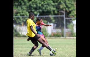 Frazsiers Whip's Shanel Buckley (background) fights for possession of the ball with Cavalier's Ashanti Lewis during a recent Jamaica Women's Premier League football encounter at Alpha Institute.