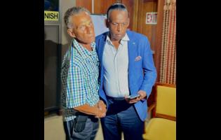 New president of the Jamaica Cricket Association (JCA) Dr Donavan Bennett shakes hands with outgoing president Wilford ‘Billy’ Heaven after the elections of officers at the Jamaica Conference Centre on Thursday.