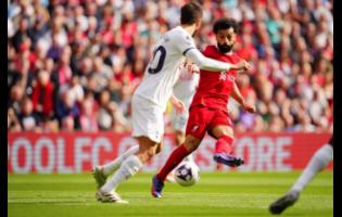 Liverpool’s Mohamed Salah (right) kicks the ball past Tottenham Hotspur’s Rodrigo Bentancur during the English Premier League football match at Anfield Stadium in Liverpool, England, yesterday. Liverpool won 4-2.