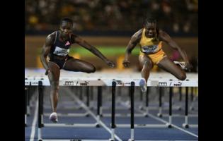 Nigeria’s Tobi Amusan (left) goes over the final hurdle ahead of Jamaica's Danielle Williams to win the women's 100 metres hurdles at the Jamaica Athletics Invitational at the National Stadium tonight.