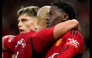 Manchester United’s Kobbie Mainoo celebrates with teammates after scoring their opening goal during the English Premier League football match against Newcastle United, in Manchester, England, yesterday. Manchester won 3-2.