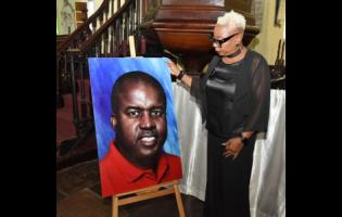 Valerie Lawrence, a cousin of Hubert Lawrence, looks at his picture on display during his remembrance service at The Cathedral of St Jago de la Vega in Spanish Town, St Catherine, recently.