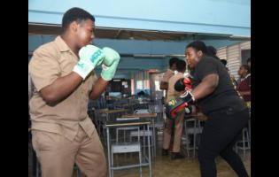 American Boxing Confederation’s woman heavyweight champion of the Caribbean, Jasmine Graham (right), demonstrates boxing techniques to Herbert Morrison Technical High School’s Javier Smith during a Lola Cunningham Foundation boxing workshop programme held at the school in April.