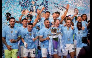 Manchester City’s Kyle Walker and teammates celebrate with the trophy after their English Premier League (EPL) match against West Ham United at the Etihad Stadium in Manchester, England, yesterday. City won 3-1 to secure the EPL title.