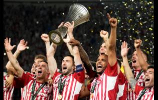Olympiacos’ Kostas Fortounis (centre, left) and Ayoub El Kaabi (centre, right) celebrate with the trophy after winning the Conference League final between Olympiacos FC and ACF Fiorentina at OPAP Arena in Athens, Greece, yesterday. Olympiacos won 1-0. 