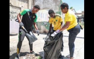 From left: Reggae Boys Richard King and Kaheim Dixon happily join forces to beautify Fleet Street, downtown Kingston on Labour Day, with Michka Smith, executive assistant to the head of human resources and administration at Supreme Ventures Limited.