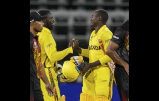 Uganda’s Kenneth Waiswa (second left) and captain Brian Masaba shake hands to celebrate the team’s three-wicket victory over Papua New Guinea in an ICC Men’s T20 World Cup cricket match at Guyana National Stadium in Providence, Guyana on Wednesday.
